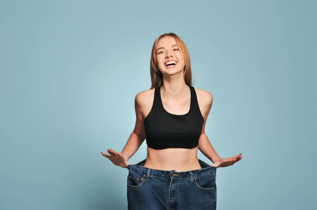 Young woman smiling while standing inside oversized jeans